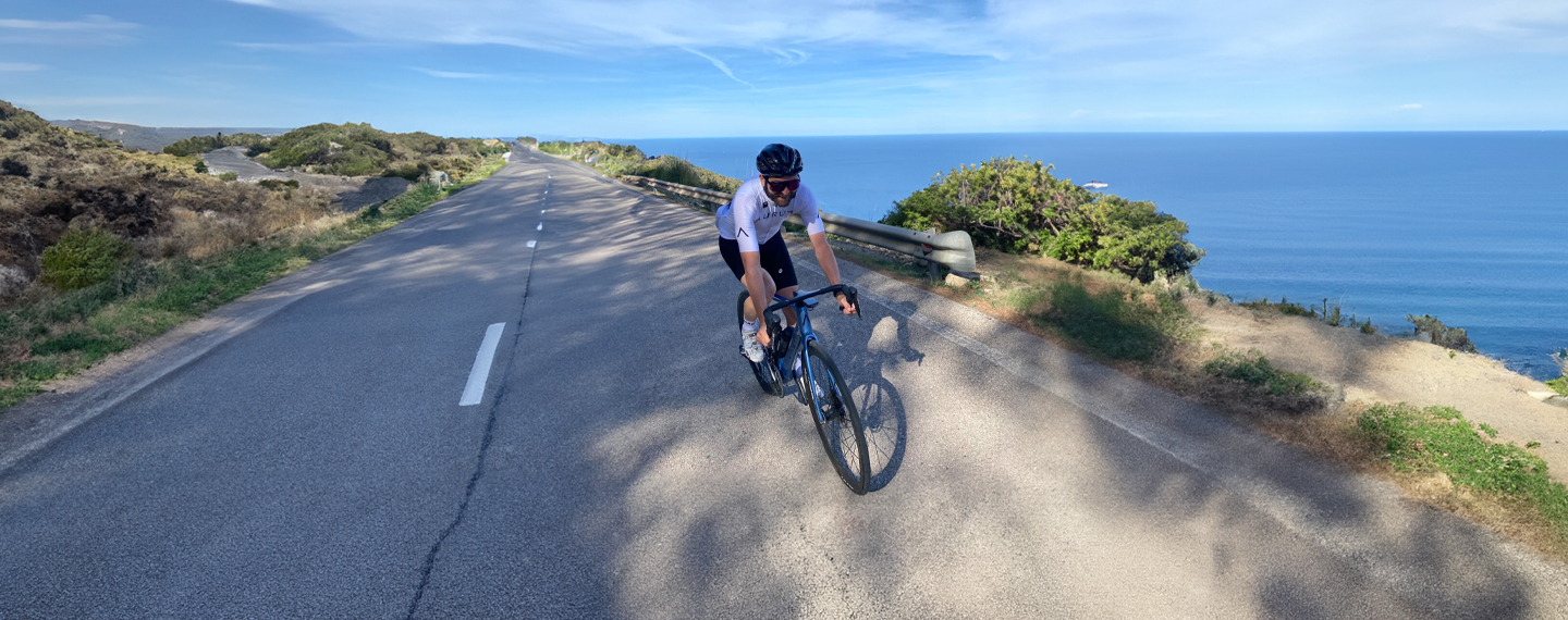 Man on bicycle riding on a coastal road in Mallorca